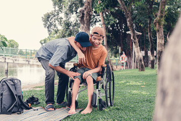 Disabled child on wheelchair​ and father have fun with activity on the outdoor park on travel, Lifestyle in education age of disabled children, Happy disability kid concept.