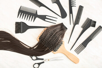 Barber set with strand of brunette hair on white background