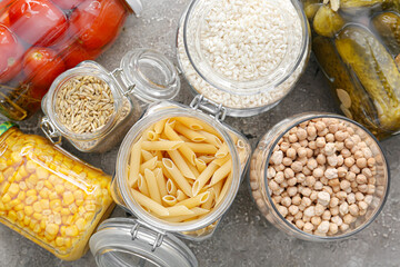 Glass jars with different products on grunge background