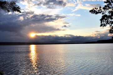 View from the shore to the lake at sunset on a clear summer evening.