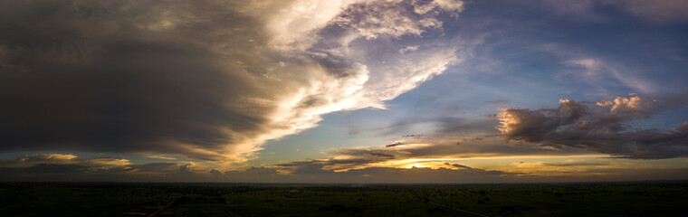 Panorama Top view Aerial photo from flying drone over rice fields and small village in Thailand.Top view beautiful Sunset.Sunrise with cloud rainy storm.