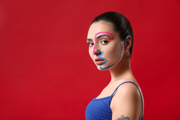 Beautiful young woman with paint on her face against color background