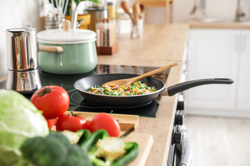 Frying pan with tasty rice on kitchen stove