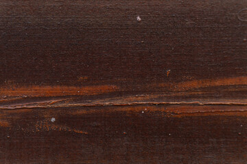 Ciemno brązowe drewniane tło, tekstura desek z pęknięciami.