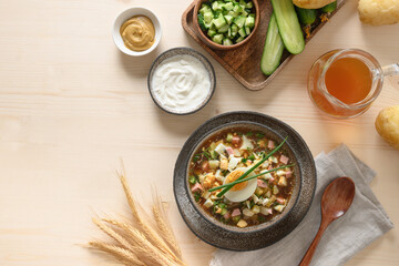 Summer Russian cold soup Okroshka with kvass, fresh chopped vegetables on a wooden background. View from above. Copy space. Russian and Ukrainian cuisine.