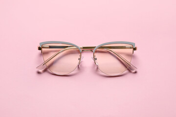 Stylish eyeglasses on color background