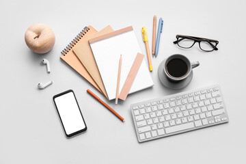 Different office tools, cup of coffee, glasses and devices on grey table