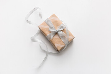 Gift box with silver ribbon on white background