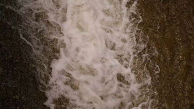 water flows from the dam with foam