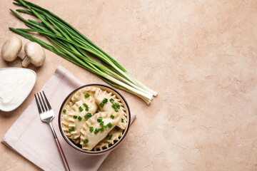 Bowl with tasty dumplings, sour cream and fresh ingredients on grunge background