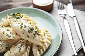 Plate with tasty dumplings on table, closeup