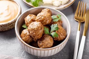  Traditional swedish meatballs with creamy sauce and mashed potatoes on gray table close up