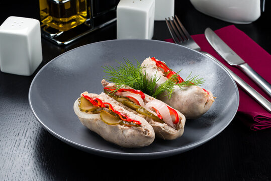 Pickled sausages with onion and red pepper. Marinated food on plate.