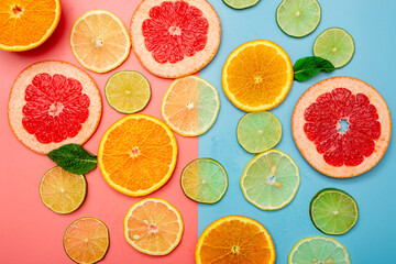 Fototapeta na wymiar summer background concept: sliced orange, grapefruit, lemon, lime on pink and blue background