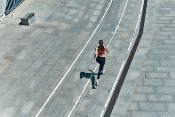 Top view of young woman in sports clothing running outdoors