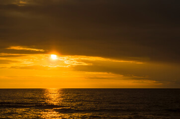 Obraz premium Beautiful summer sunset over the baltic sea. The sun's rays pass through the clouds