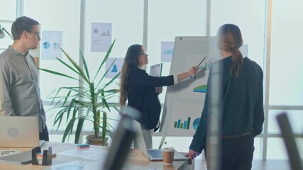 Successful Pregnant Woman, Working With Colleagues in Modern Office, Presents Data From the Financial Graph, Showing Information on a Whiteboard. Modern Working Woman in Late Pregnancy. - Powered by Adobe