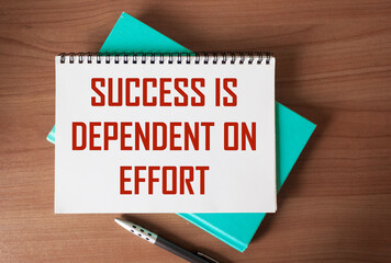 Text on notepad: Success is depends on effort. Motivational quote