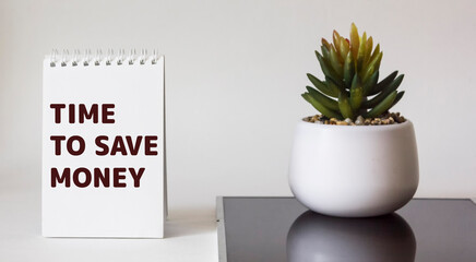 Time to save money writing on notepad, business concept. On a white and black background.