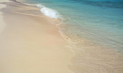 Fototapeta na wymiar Beautiful turquoise ocean water, light waves hitting the white sandy tropical beach
