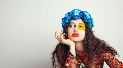 Portrait of a girl with floral wreath and creative makeup
