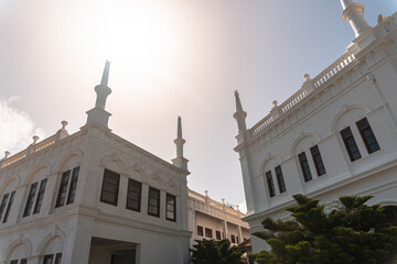 Biały piękny meczet na tle nieba i słońca.