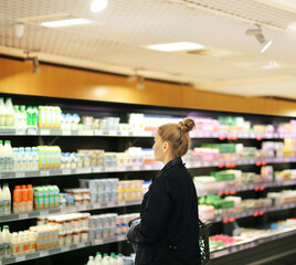 Woman choosing a dairy products at supermarket