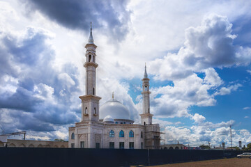 Fototapeta na wymiar A mosque under a blue cloudy sky. A Muslim mosque under construction on a sunny day.