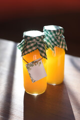 Natural orange juice in labeled glass jars for two