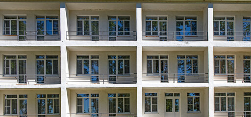fragment of a facade of a building with balcony with table and chair