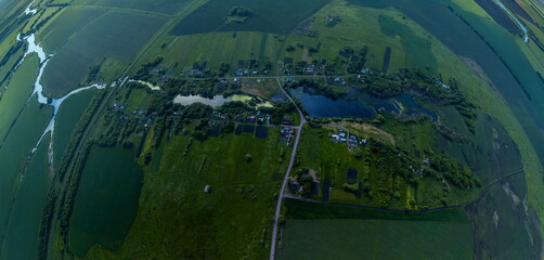 small village Kalikino (Tambov region, Russia) by a pond surrounded by green fields -  view from a height on a sunny day
