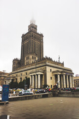 Warsaw, Poland: Wide angle vertical shot of Palace of Culture and Science famous tourist attraction covered by fog at the top.