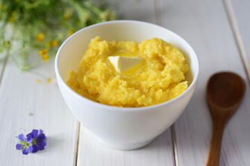Vegetarian breakfast: millet porridge with butter in a white plate.
