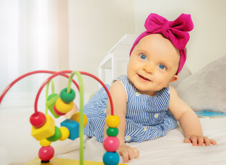 Fototapeta na wymiar Infant girl play with bead roller coaster toy