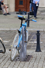 Stare rowery zaparkowane na stojaku w mieście. - obrazy, fototapety, plakaty