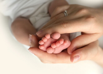 hands of parents. the legs of the newborn in the hands of mom and dad. baby's legs in his hands. 