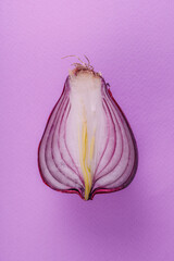 A cut of fresh red onions on a purple background