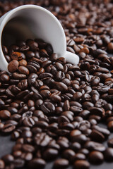 Cup with roasted coffee beans. Close up shot. cups on  table with scattered coffee beans. Soft focus.