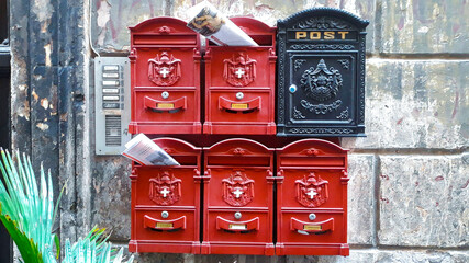 Mailboxes of different colors with newspapers