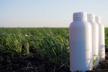 White canister against the background of agriculture, canisters from under different types of chemical products.