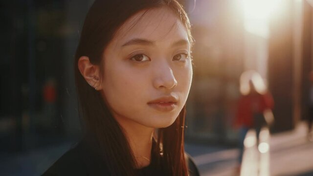Outside portrait of amazing young japanese woman with straight black hair and beautiful eyes smiling cheerfully in the street. Females. People in city.