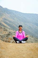 Naklejka na ściany i meble mature woman meditating on the mountain in sportswear