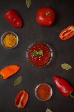 ketchup in a bowl and ingredients for its preparation, tomatoes, paprika and spices