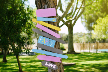 Signpost with wooden signs and arrows in various colors, festive concept