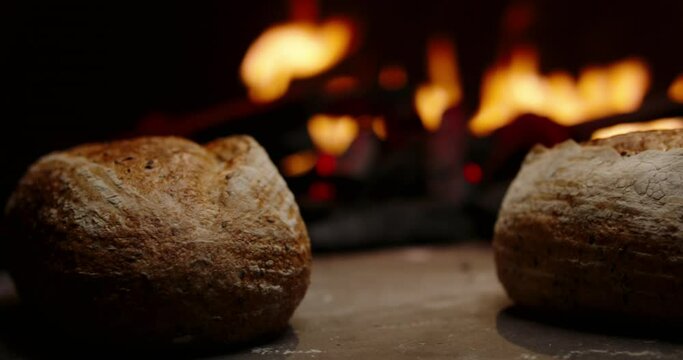 Fresh loaves of organic bread being cooked in authentic stone oven. Traditional recipes of cooking homemade bread with natural ingredients 4k footage close up