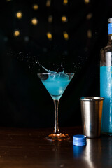 Cóctel de color azul con salpicaduras al caer el hielo