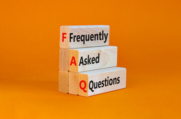 FAQ frequently asked questions symbol. Concept words 'FAQ frequently asked questions' on wooden blocks on a beautiful orange background. Business and FAQ frequently asked questions concept.