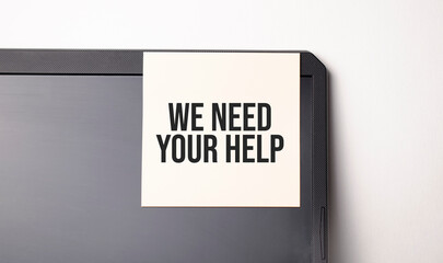 Sticky note on the computer. Text We need your Help