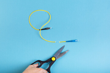 Destroy optical SC fiber by scissors. Isolated on blue