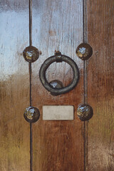 Detail of antique entrance door with reddish wood